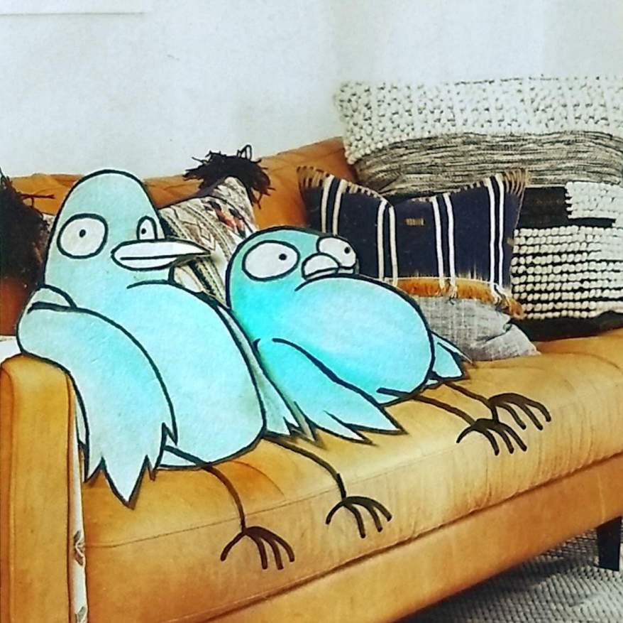 Two birds sitting on a couch.